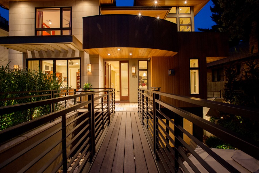 A walkway leading to a well-lit two-story home.