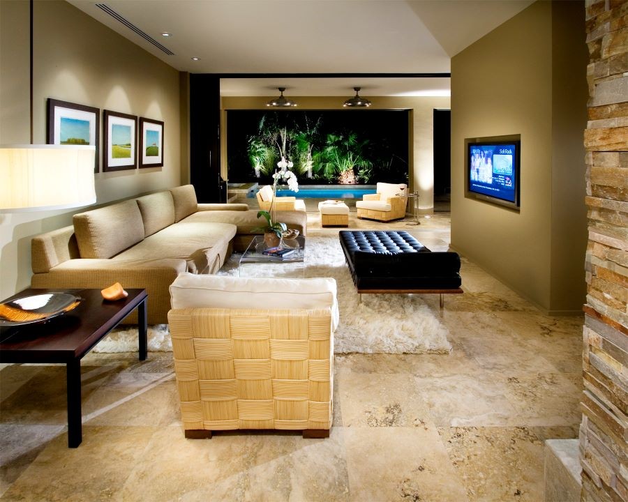 A living room with an in-wall TV and an open area to the pool.