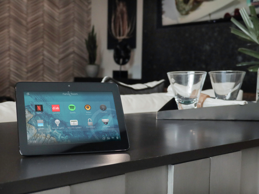 Image is of a Control4 control tablet on a table in a living room.