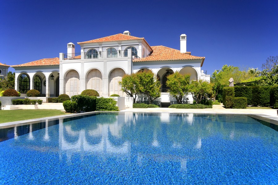 A large luxury home with an expansive pool.