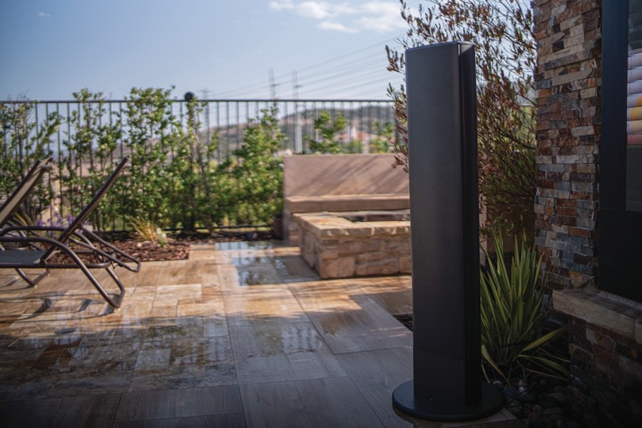 A James Loudspeaker brand outdoor tower speaker sits in a bricked-in patio area